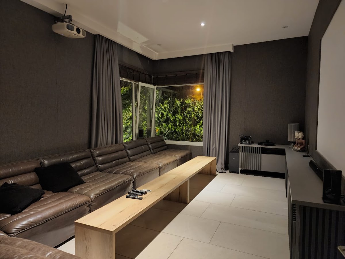 Sala de cine privada con sofá modular y proyector